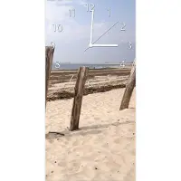 Wallario Design Wanduhr bedruckt, Größe 30 x 60 cm, Motiv: Sandstrand mit Holzpfählen am Atlantischen Ozean