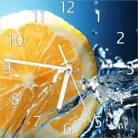 Wallario Design Wanduhr Orange in spritzigem Wasser vor blauem Hintergrund aus Echtglas, Größe 20 x 20 cm