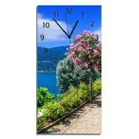Wallario Design Wanduhr Blütenpromenade am Seeufer aus Echtglas, Größe 30 x 60 cm