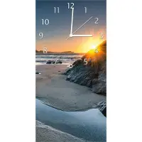 Wallario Design Wanduhr bedruckt, Größe 30 x 60 cm, Motiv: Sonnenuntergang hinter einem Felsen am Strand